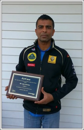 Rishard Zakky, founder of RZ Auto Services, holding the AirCare award